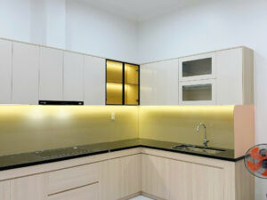 Thi công mẫu tủ bếp chữ L hiện đại PVC012 kết hợp cánh acrylic bóng gương và tủ trang trí kính